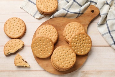 Photo of Fresh tasty sandwich cookies on wooden table, top view