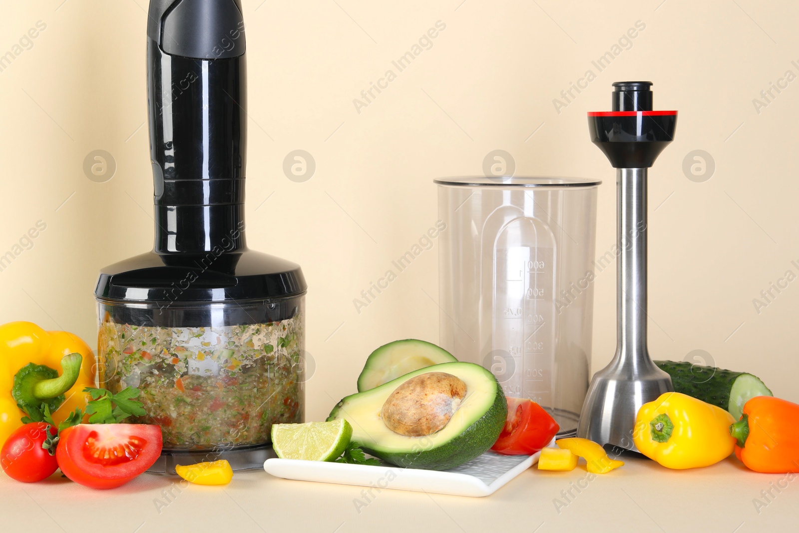 Photo of Hand blender kit and fresh products on beige background