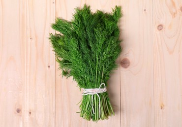 Photo of Bunch of fresh green dill on wooden table, top view