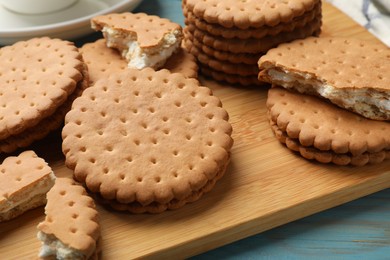 Tasty sandwich cookies on light blue wooden table, closeup