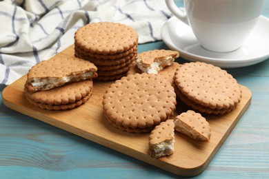 Tasty sandwich cookies on light blue wooden table, closeup