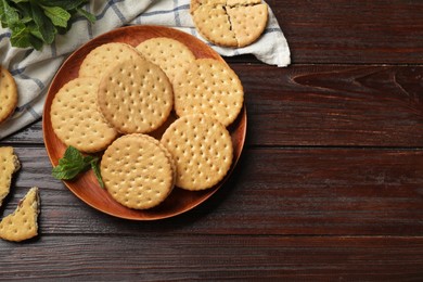 Photo of Tasty sandwich cookies and mint on wooden table, flat lay. Space for text