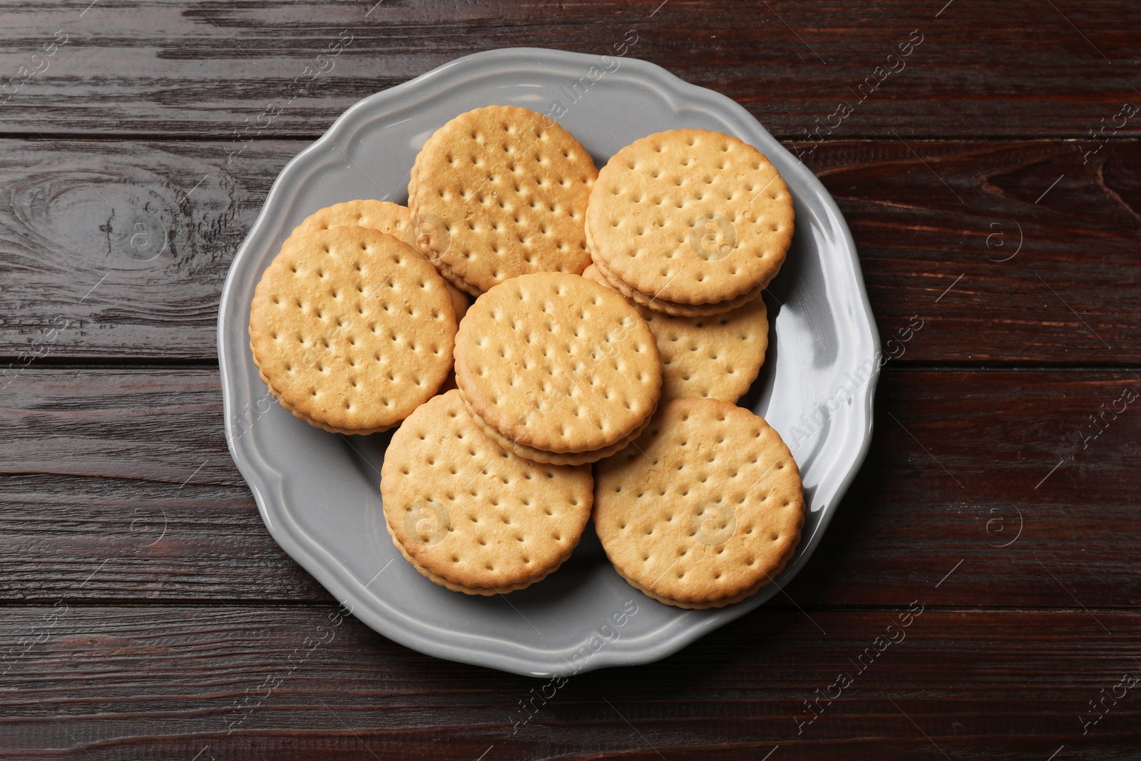 Photo of Tasty sandwich cookies on wooden table, top view