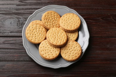 Photo of Tasty sandwich cookies on wooden table, top view