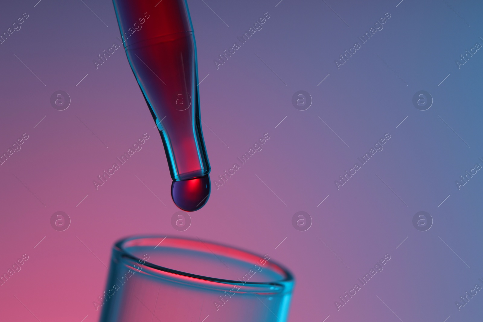 Photo of Dripping liquid from pipette into test tube on color background, closeup. Space for text