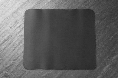 Photo of One mouse pad on black textured table, top view. Space for text