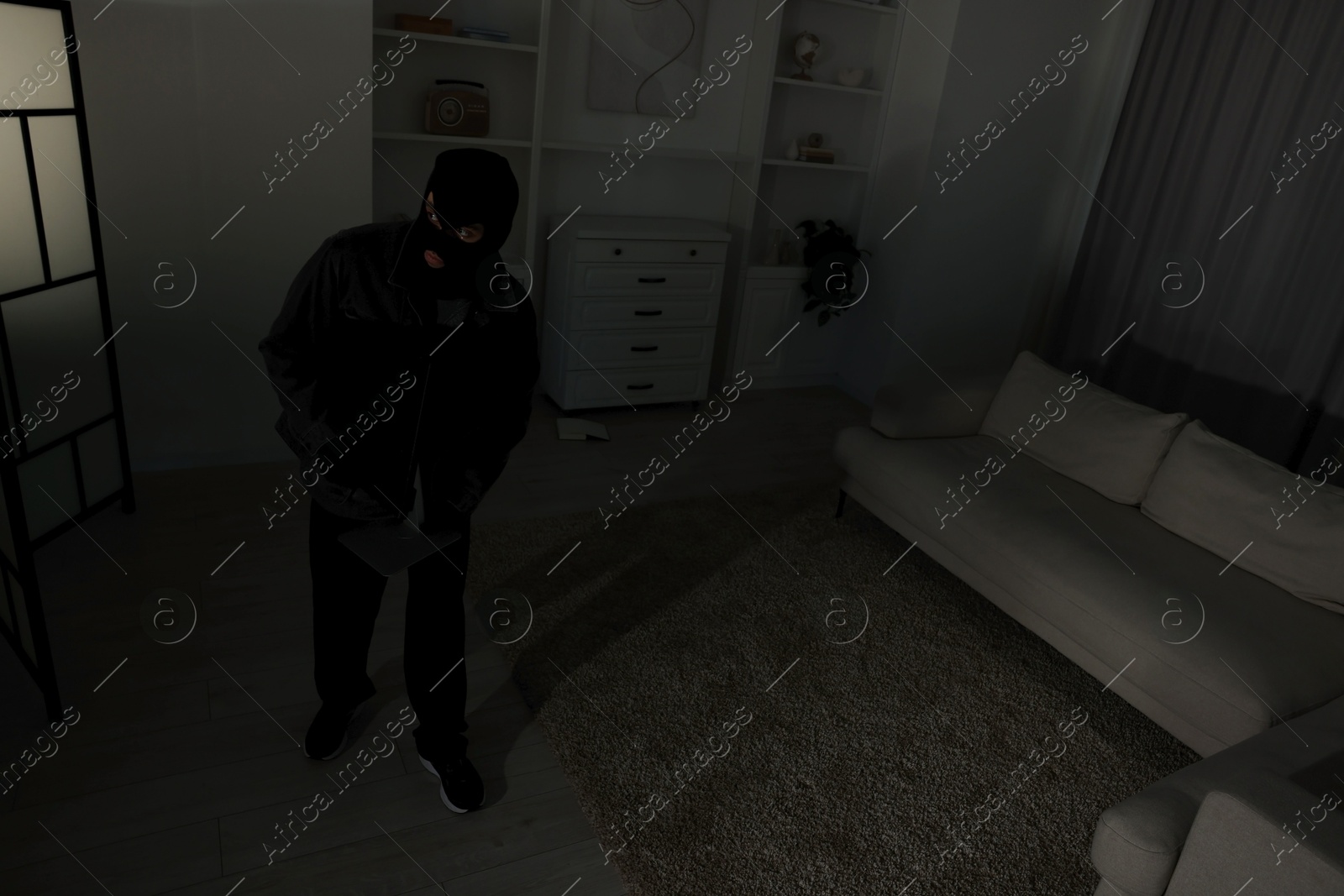 Photo of Thief entering foreign house at night. Burglary