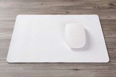 Wireless mouse and mousepad on wooden table