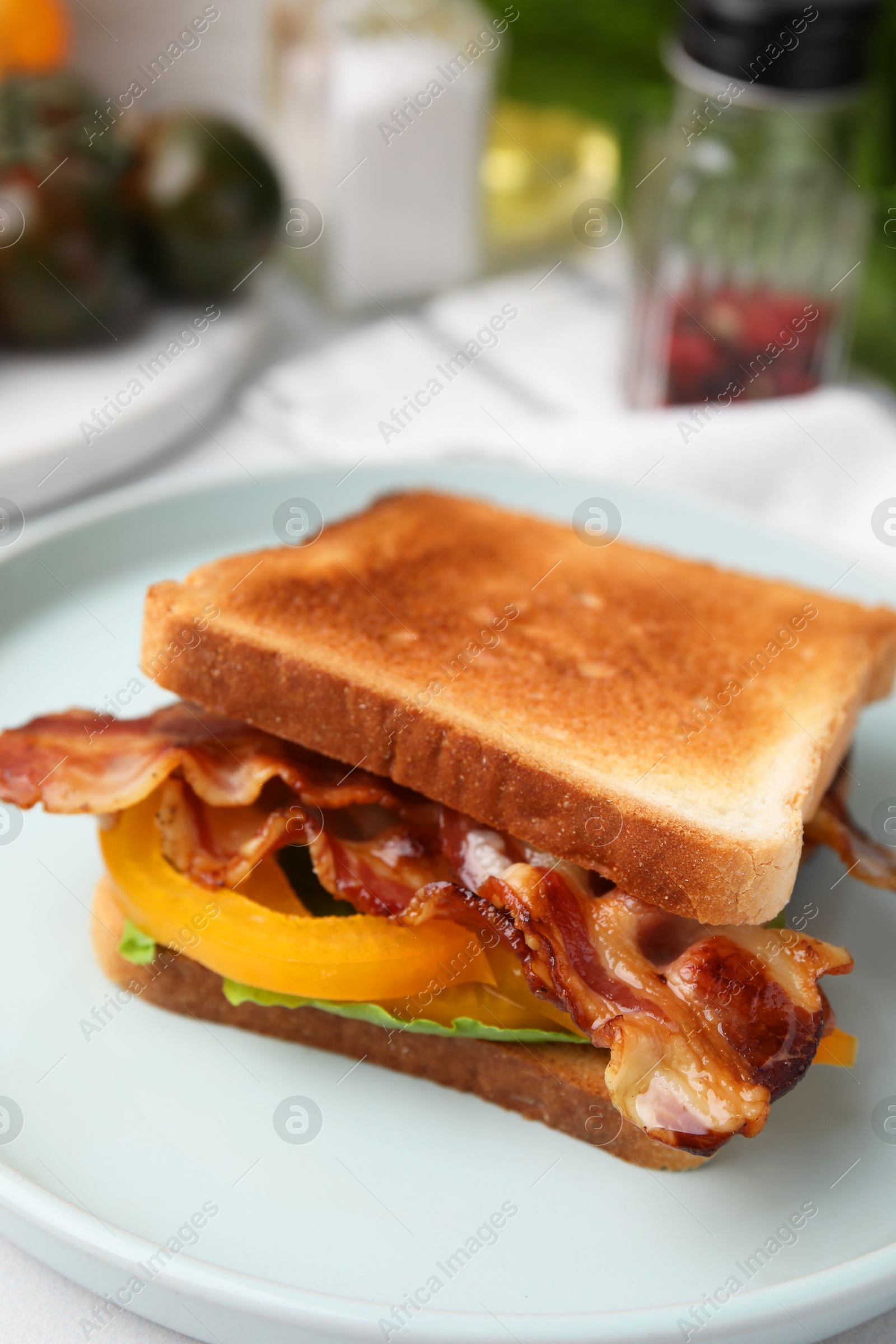 Photo of Tasty sandwich with bacon and bell pepper on white table, closeup