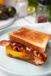 Photo of Tasty sandwich with bacon and bell pepper on white table, closeup