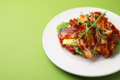 Photo of Tasty sandwich with bacon and microgreens on green table. Space for text