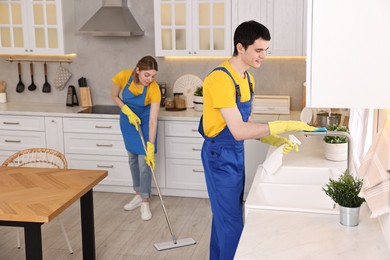 Photo of Professional janitors working in kitchen. Cleaning service