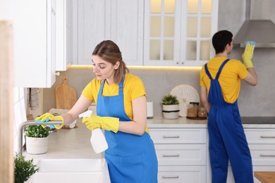 Photo of Professional janitors working in kitchen. Cleaning service