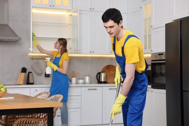 Photo of Professional janitors working in kitchen. Cleaning service