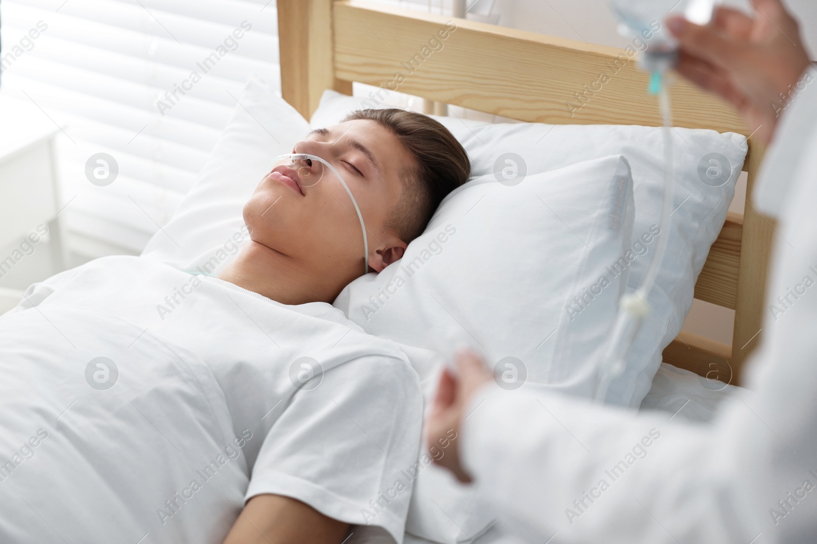 Photo of Coma patient. Doctor near unconscious young man in hospital, closeup