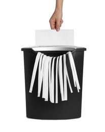 Photo of Woman destroying sheet of paper with shredder on white background, closeup