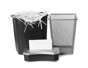 Shredder, metal basket and paper strips on white background