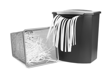 Shredder, metal basket and paper strips on white background