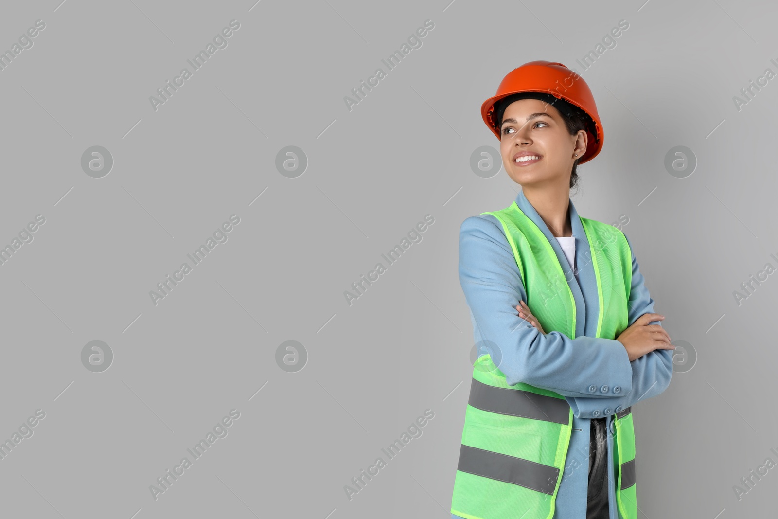 Photo of Engineer in hard hat on grey background, space for text