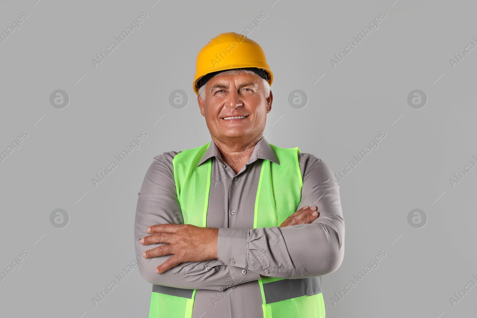 Photo of Engineer in hard hat on grey background