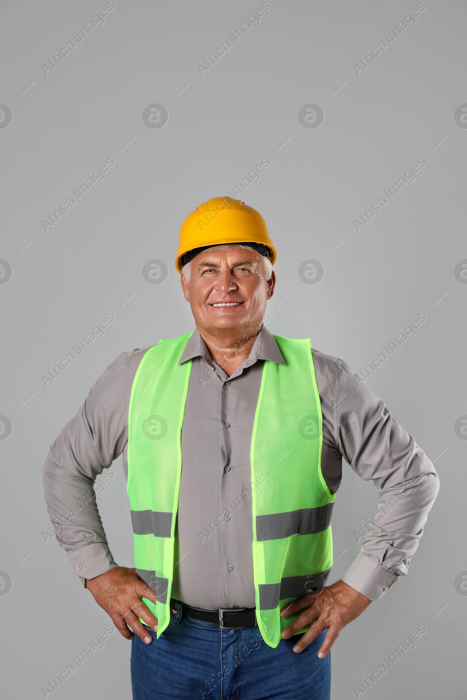 Photo of Engineer in hard hat on grey background