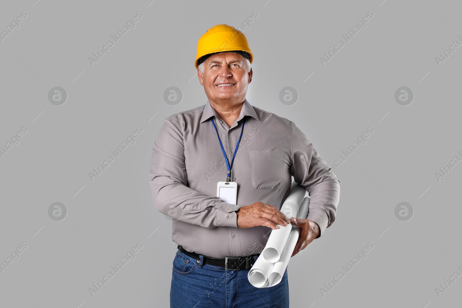 Photo of Engineer in hard hat with drafts on grey background