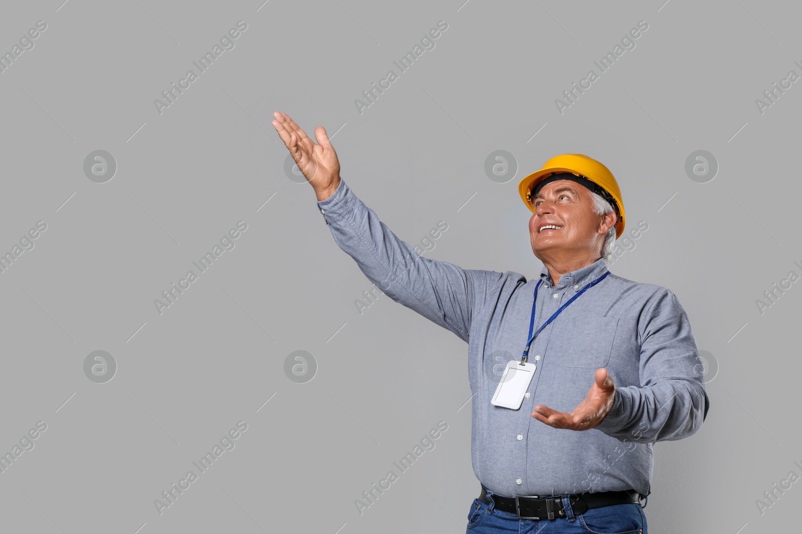 Photo of Engineer in hard hat on grey background, space for text