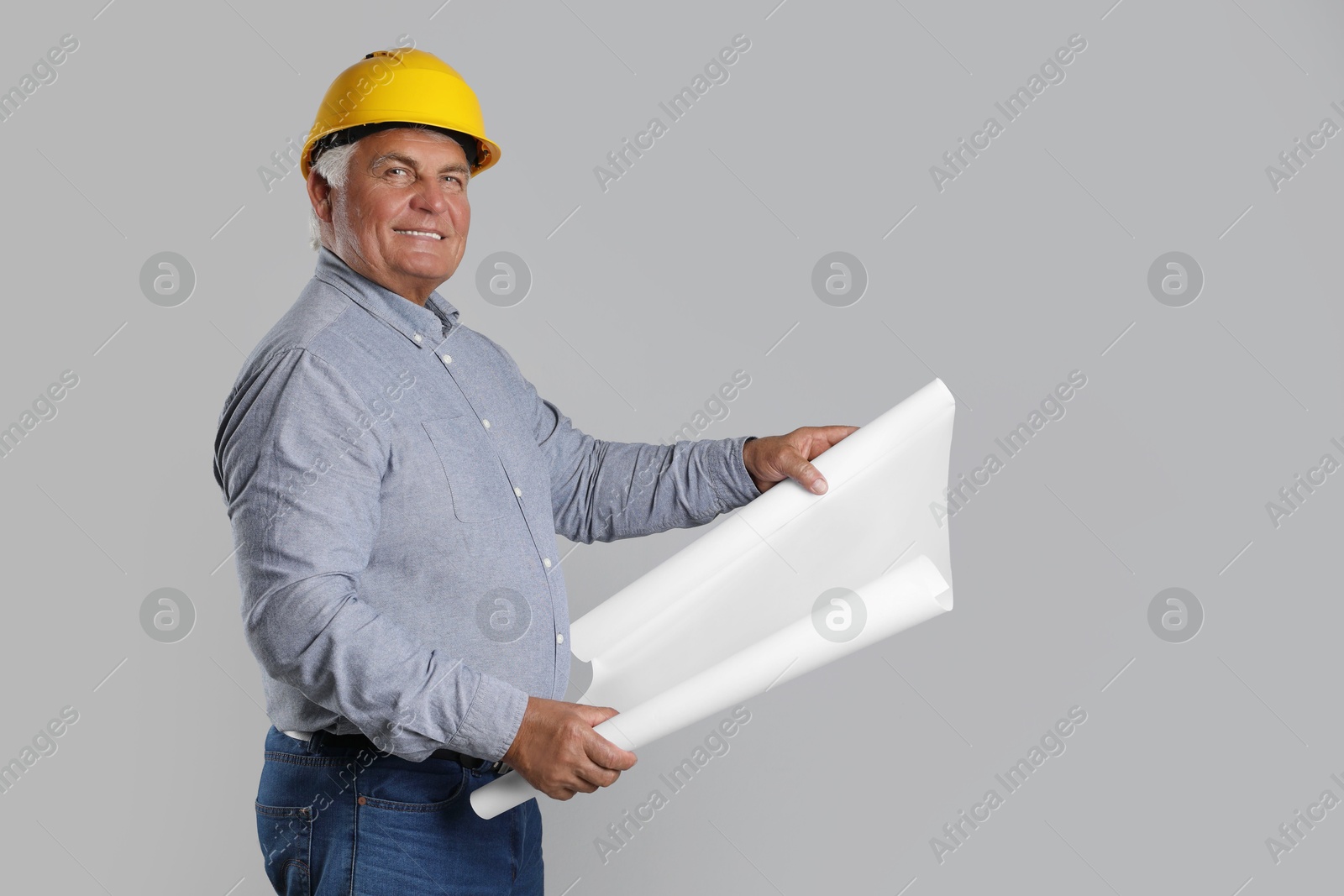 Photo of Engineer in hard hat with draft on grey background, space for text