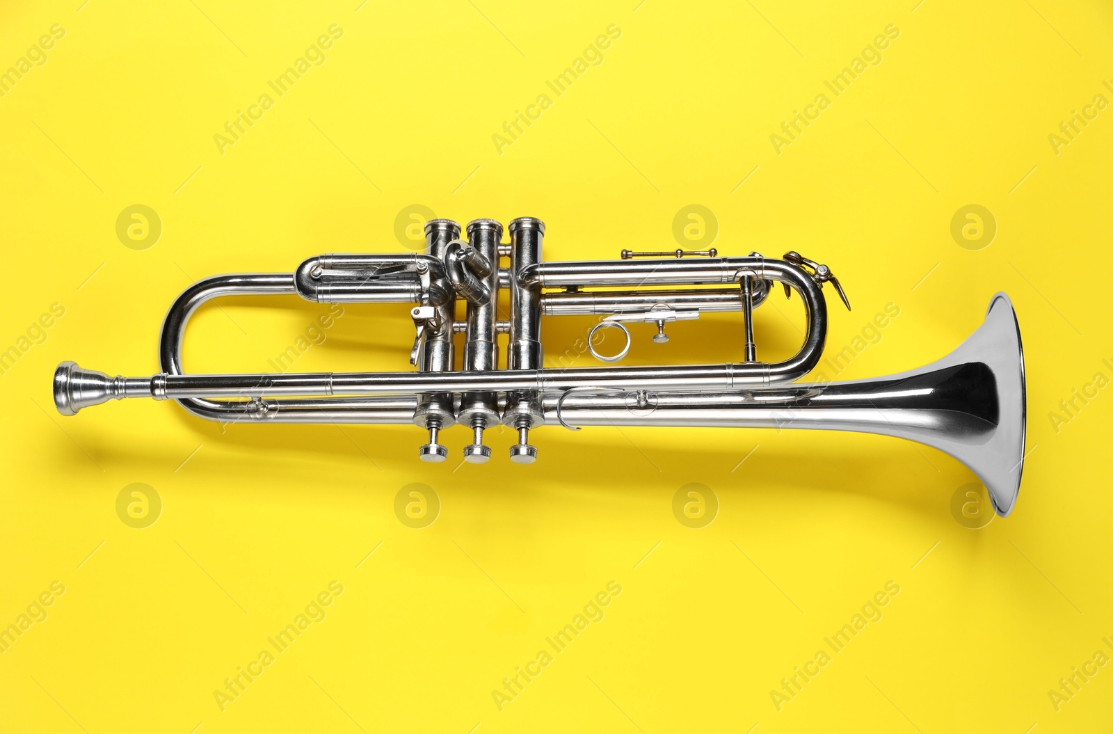 Photo of One trumpet on yellow background, top view