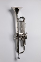 Photo of One trumpet on light background, top view