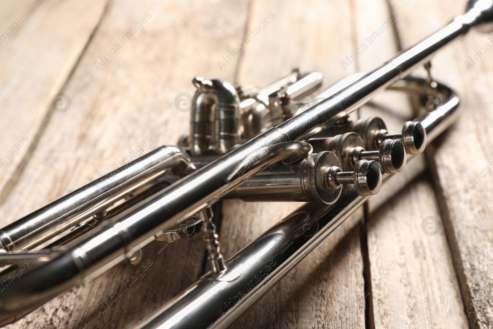 Photo of One trumpet on wooden table, closeup. Musical instrument