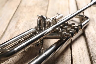 One trumpet on wooden table, closeup. Musical instrument