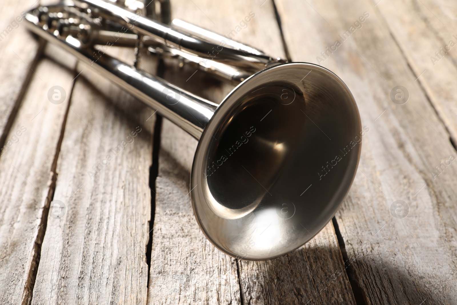 Photo of One trumpet on wooden table, closeup. Musical instrument