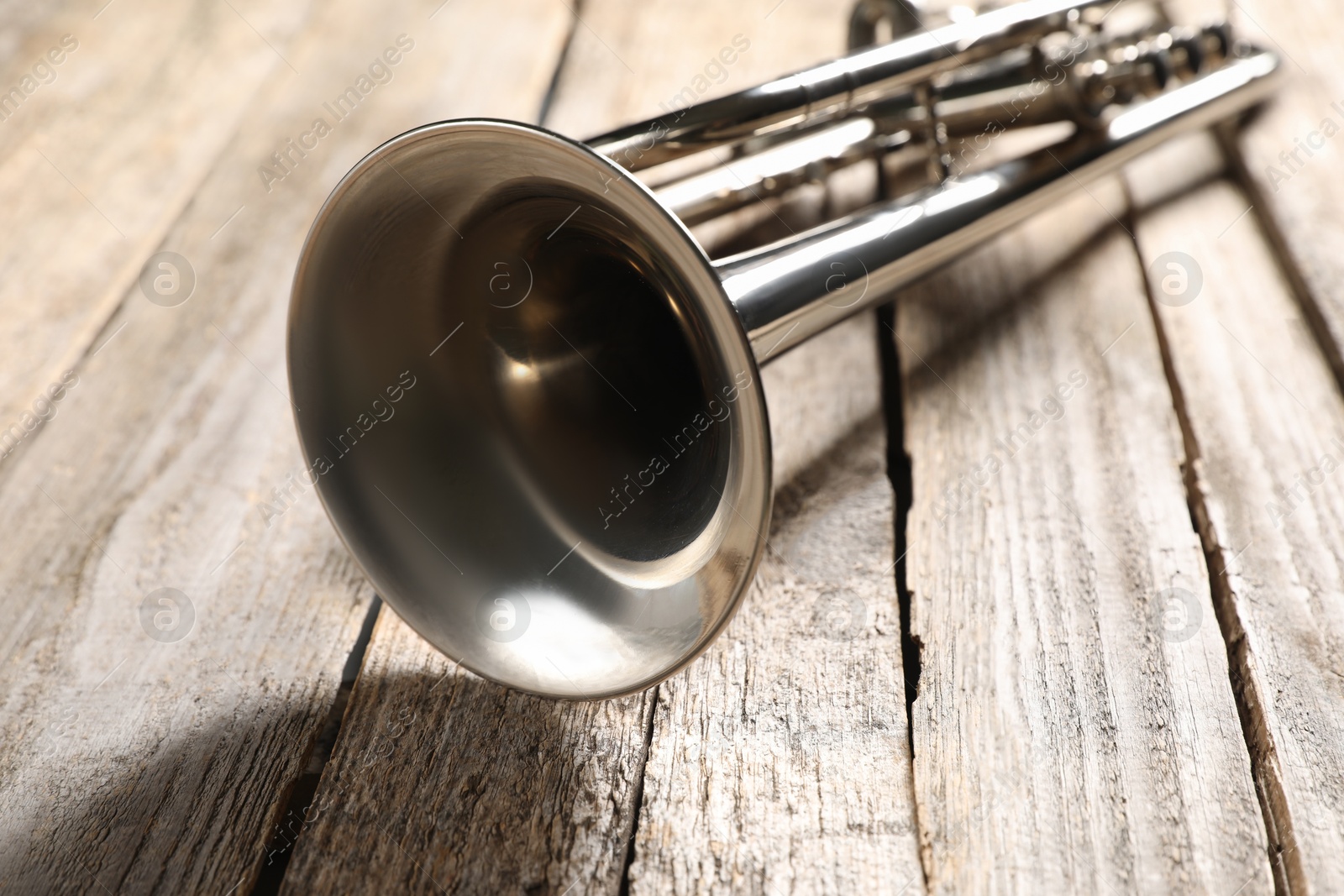 Photo of One trumpet on wooden table, closeup. Musical instrument