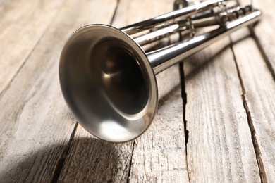 Photo of One trumpet on wooden table, closeup. Musical instrument