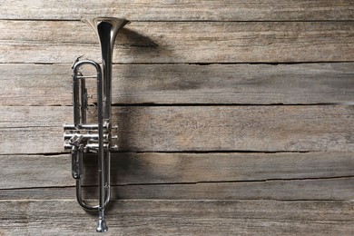 Trumpet on wooden table, top view. Space for text