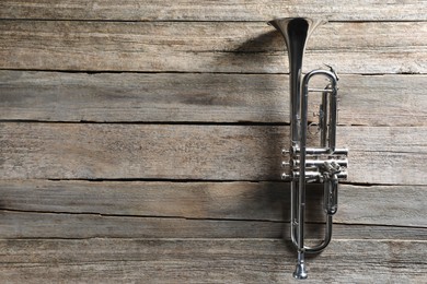 Trumpet on wooden table, top view. Space for text