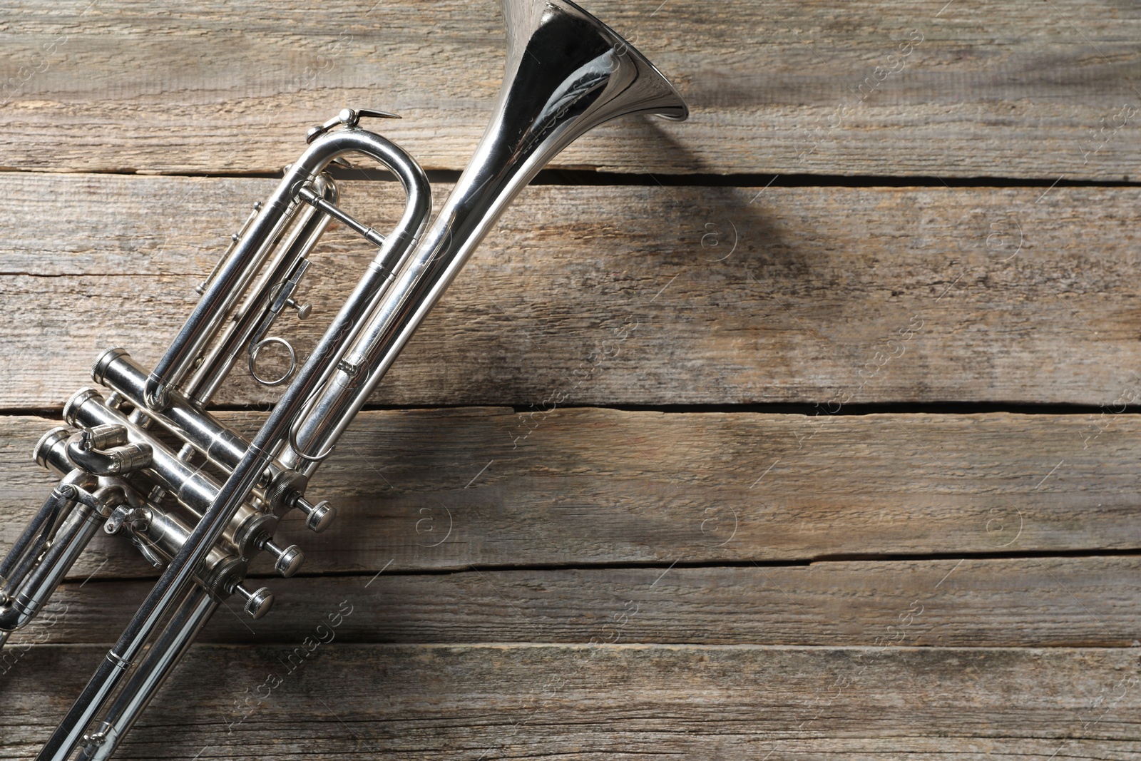 Photo of Trumpet on wooden table, top view. Space for text