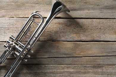 Trumpet on wooden table, top view. Space for text