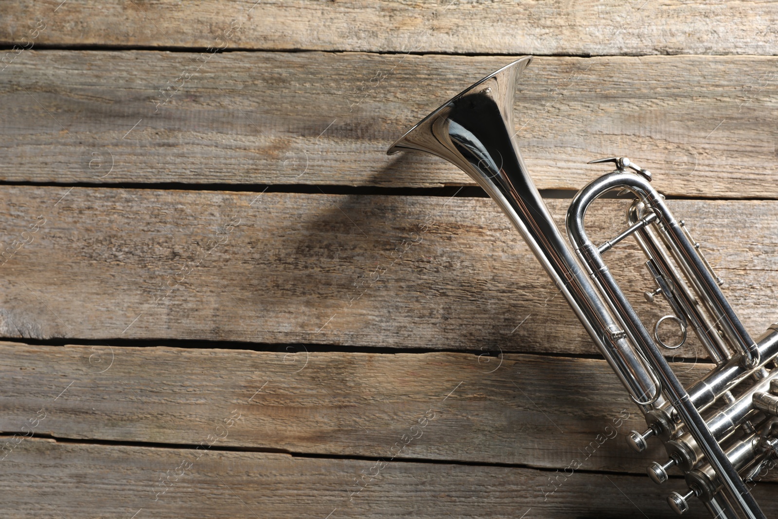 Photo of Trumpet on wooden table, top view. Space for text