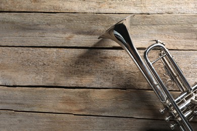 Trumpet on wooden table, top view. Space for text