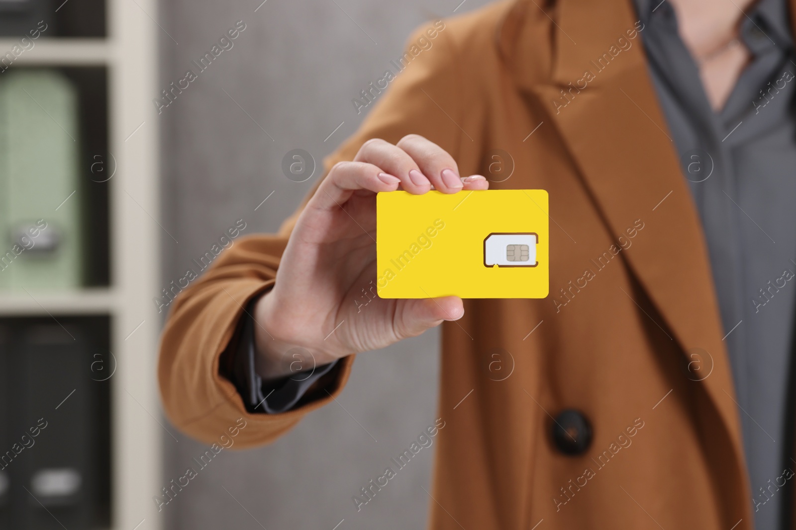 Photo of Woman holding SIM card indoors, closeup view