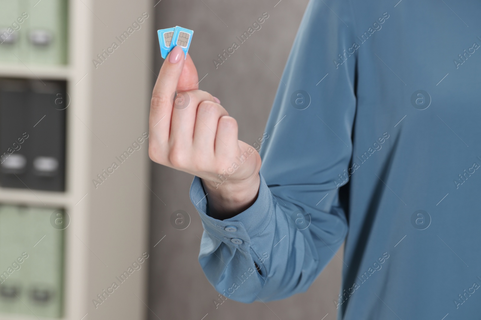 Photo of Woman holding SIM cards indoors, closeup view