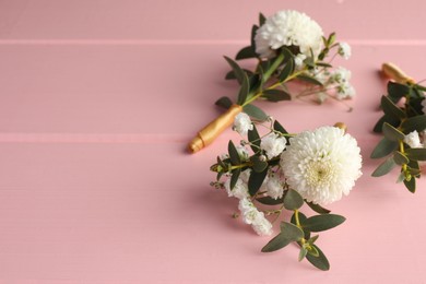 Photo of Many small stylish boutonnieres on pink wooden table. Space for text