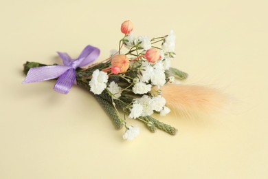 Small stylish boutonniere on beige background, closeup