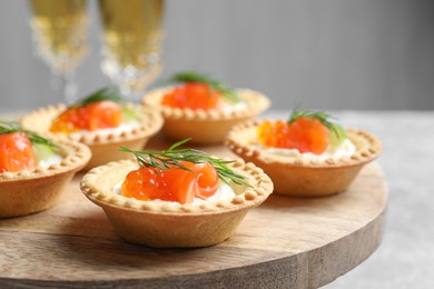 Delicious canapes with salmon and red caviar on table, closeup