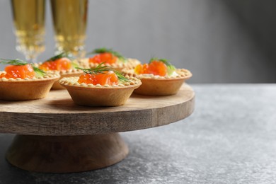 Delicious canapes with salmon and red caviar on gray table, closeup