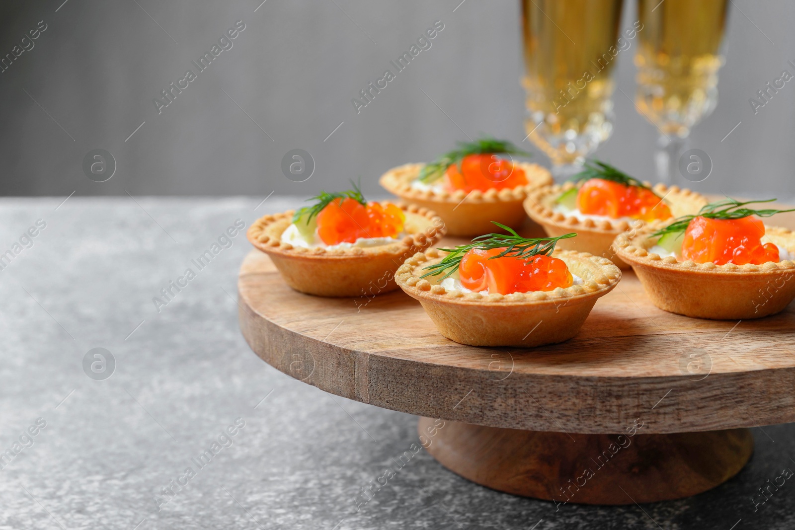 Photo of Delicious canapes with salmon and red caviar on gray table, closeup