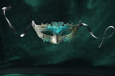 Photo of Theater arts. Venetian carnival mask against green fabric