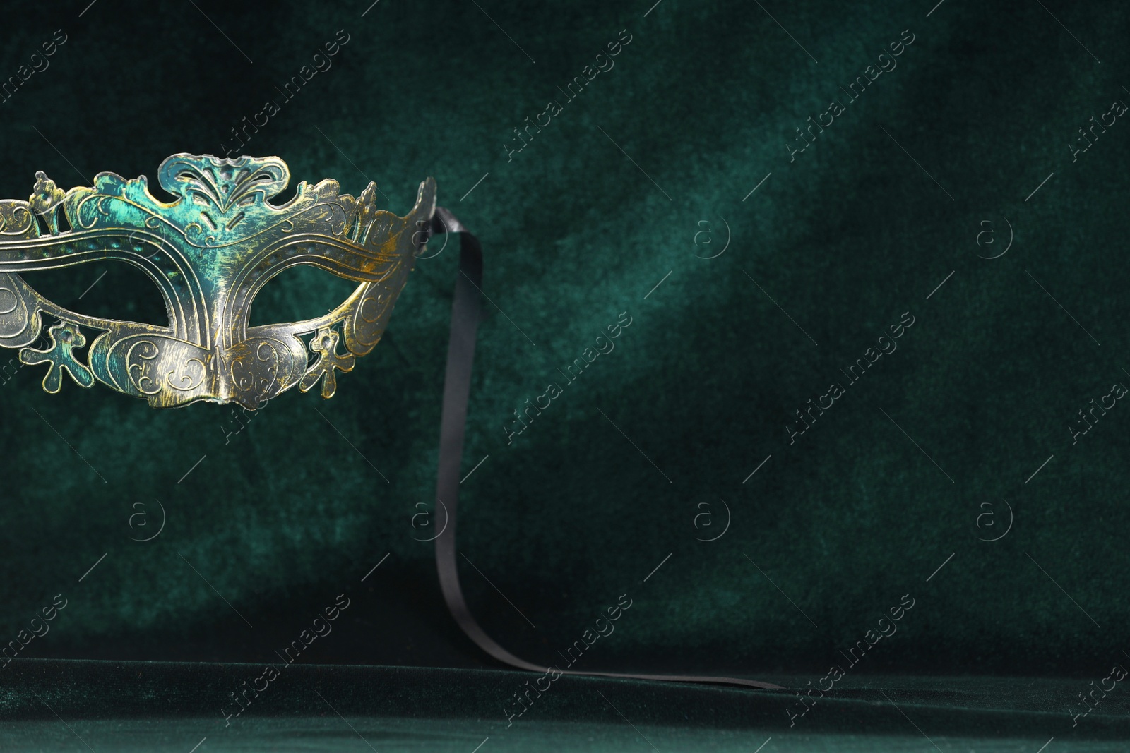 Photo of Theater arts. Venetian carnival mask against green fabric, space for text